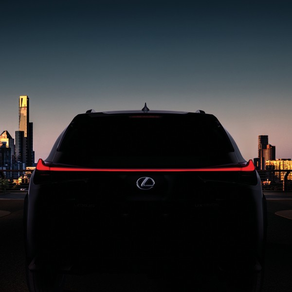 Vista trasera del Lexus UX250h con una ciudad de fondo